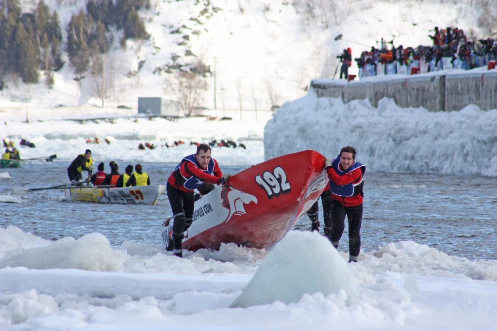 Racers pull their canoe onto the ice. Photo credit: Quebec Winter Carnival
