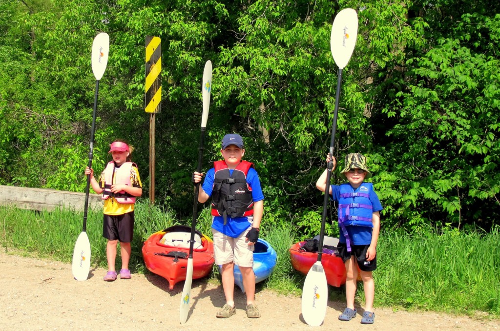 kids posing in front of kayaks for Mothers Day kayaking adventure