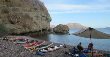Sea kayaks and a beach umbrella along the coast near Loreto, Baja Sur, Mexico